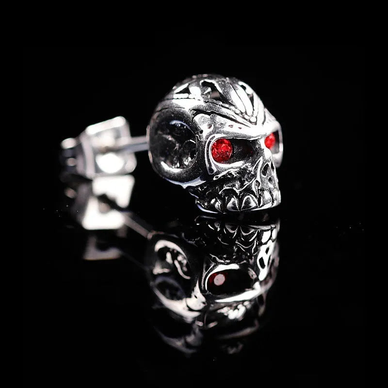 Skull stud earrings with red eye detailing on alloy base with gemstone inlay