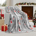 Soft flannel plush Christmas blanket in a choice of colours and multiple sizes on a sofa.