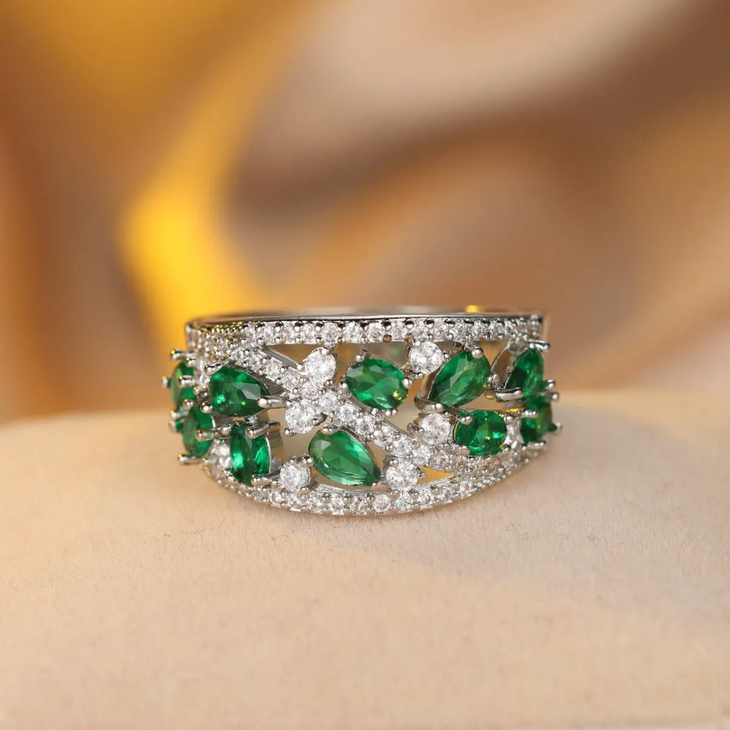 Women's round hollow fashion ring in gold or platinum plating with a central clear or blue crystal stone.