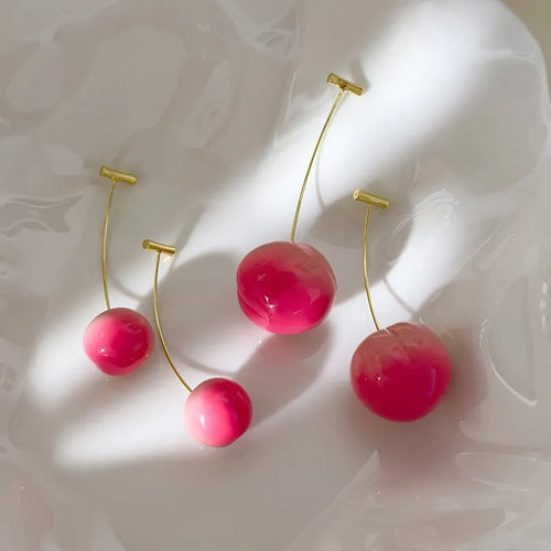 A pair of acrylic peach fruit earrings on copper posts, shown in small and large size options.