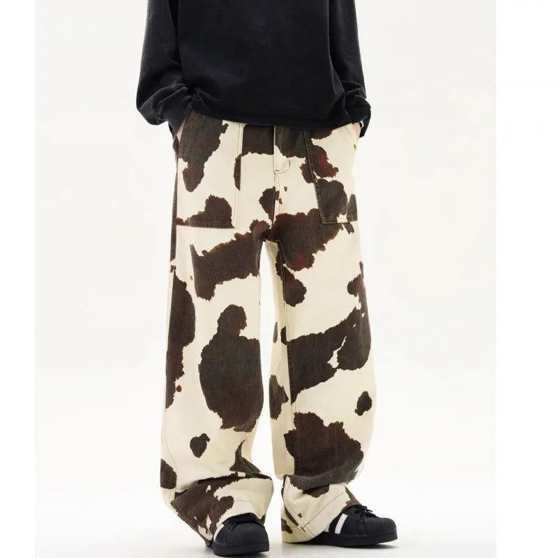 Men's straight-leg casual trousers featuring a black and white cow print pattern with a button fly.