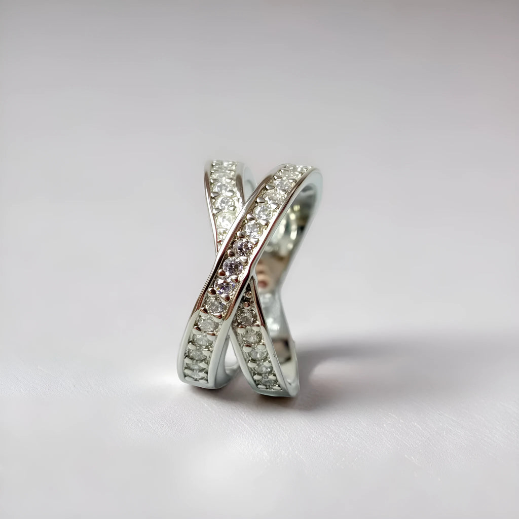 Geometric heart-shaped cross ring with a micro-inlaid zircon stone in a silver or rose gold electroplated finish.