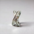 Geometric heart-shaped cross ring with a micro-inlaid zircon stone in a silver or rose gold electroplated finish.