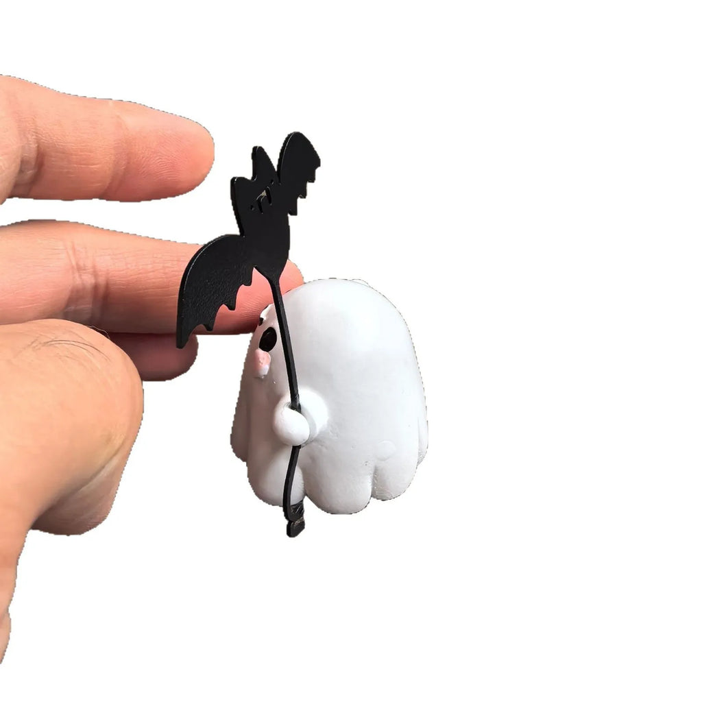 Small white resin statue of a ghost walking a bat on a Halloween lead