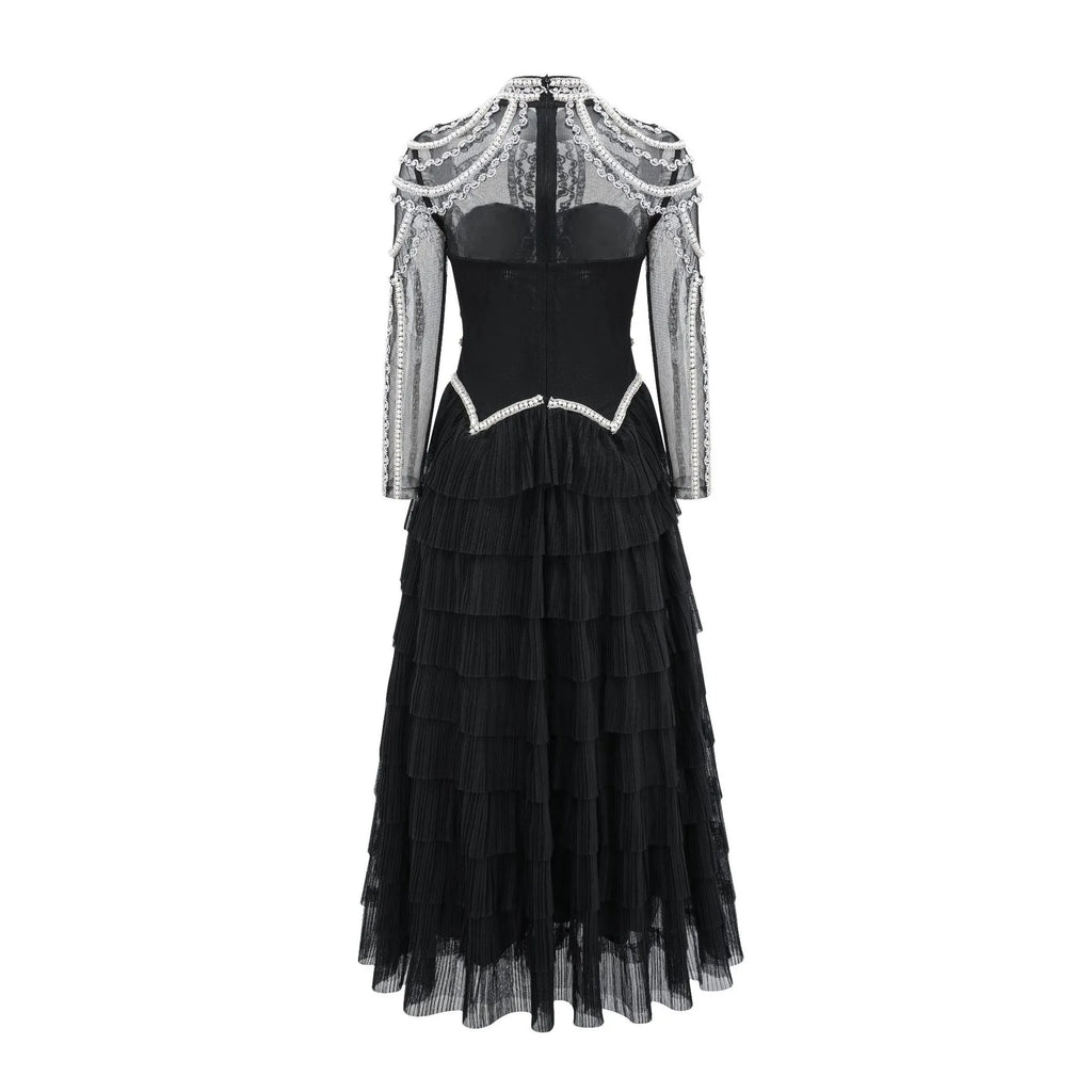 Black long sleeve women's dress with beaded decoration and a long skirt.