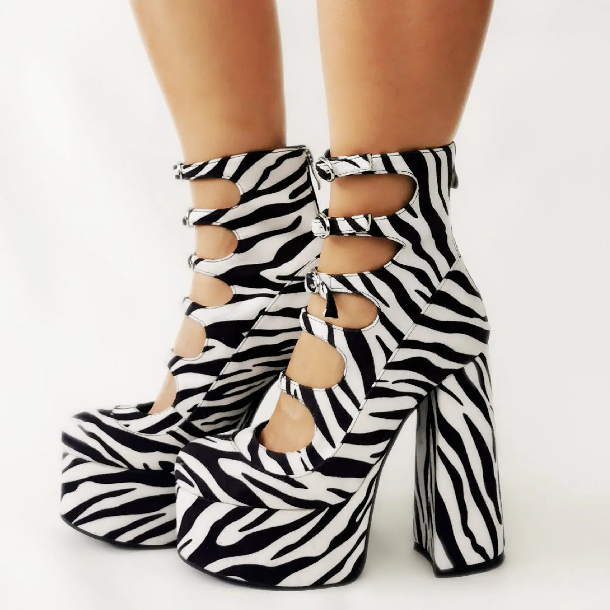 Black patent leather women's platform high heel boots with a serpentine buckle strap and round toe.