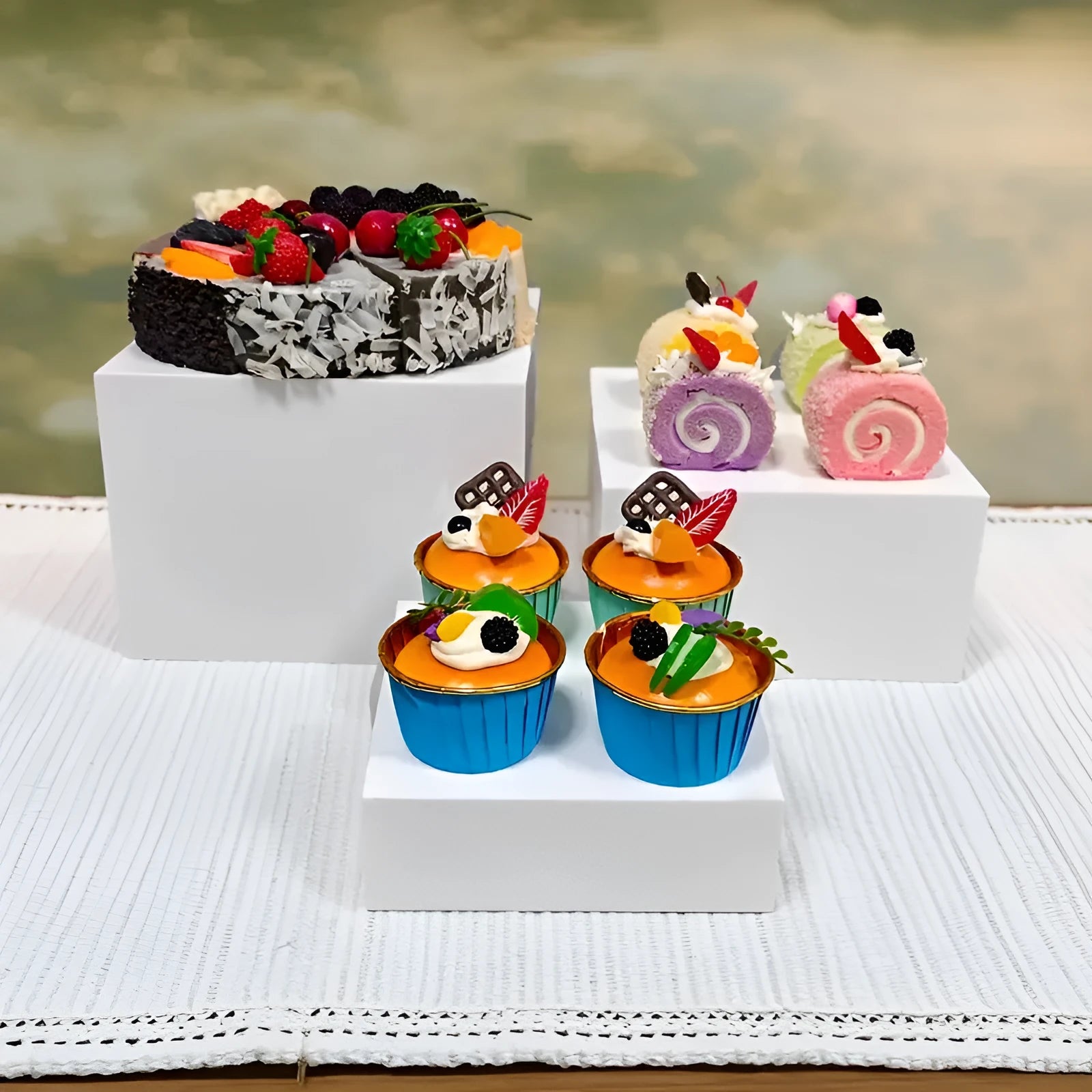 White plastic stacking cube dessert display stand set arranged in a pyramid for cakes and cupcakes.