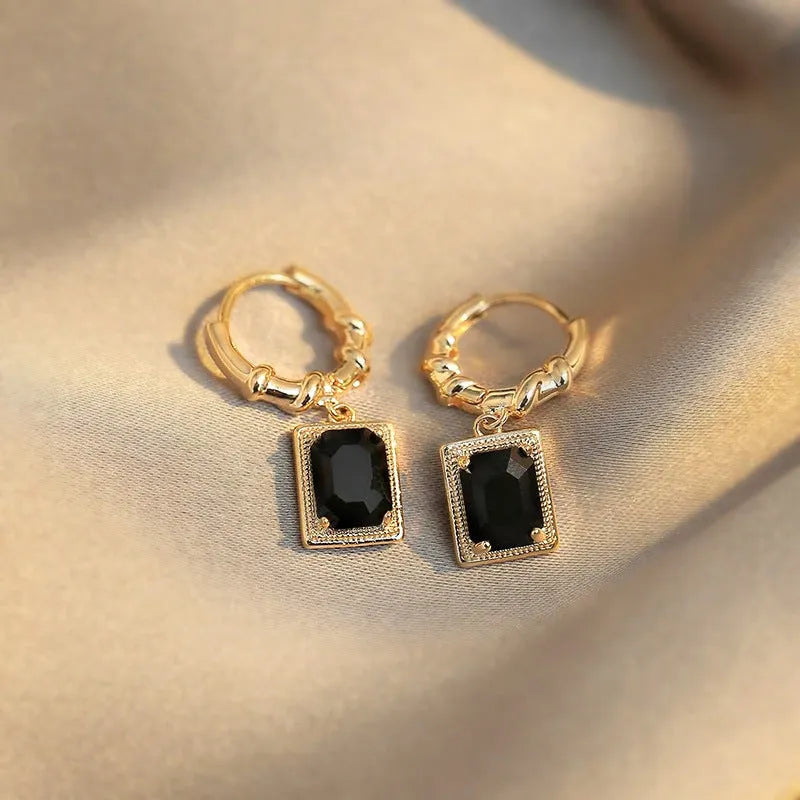 Close-up of black geometric cubic zirconia earrings with a quadrilateral design and butterfly clutch backs.