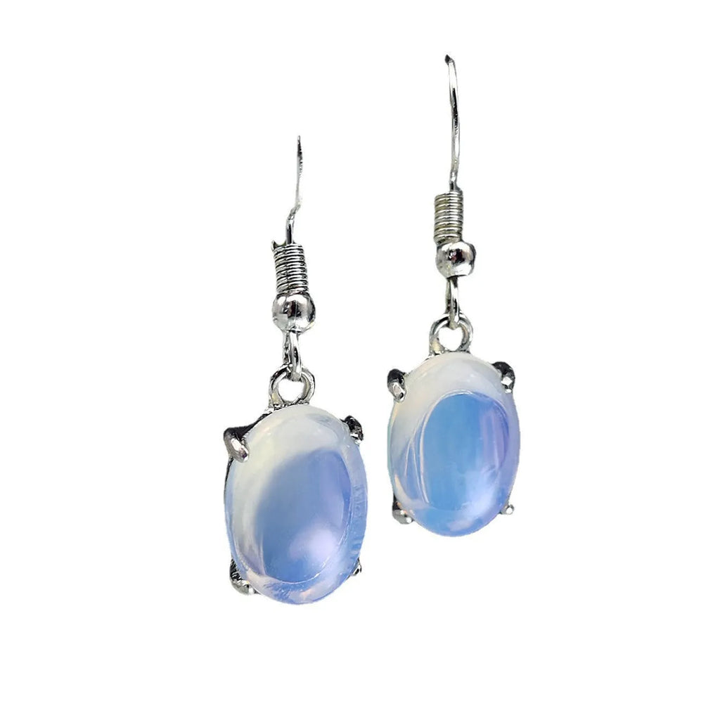 Close-up of moonlight white opal drop earrings with a cross pendant on an alloy post.