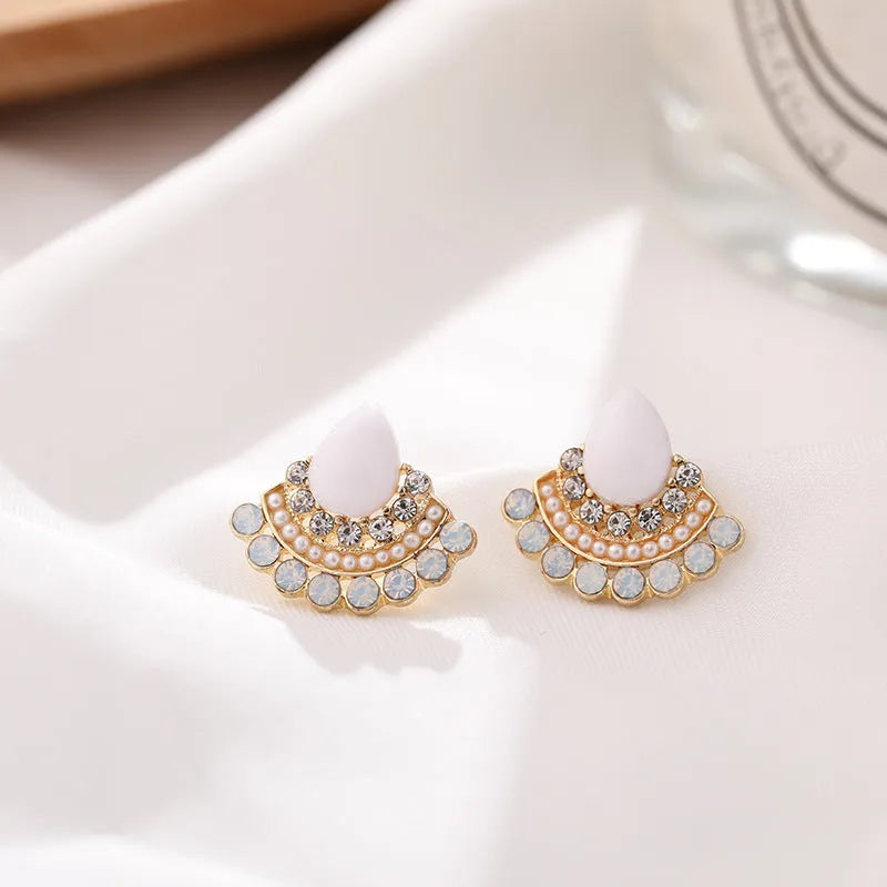 A pair of silver retro fan-shaped stud earrings with rhinestone details on a geometric design.