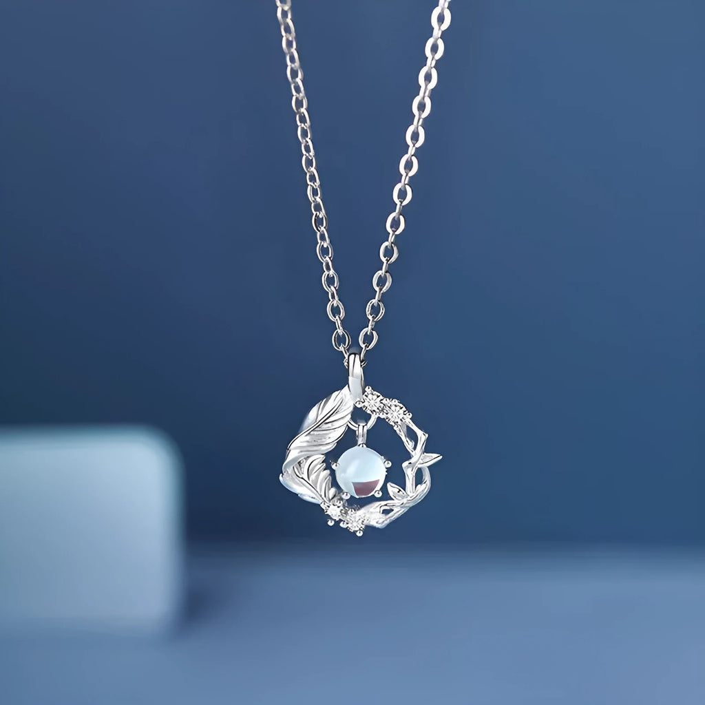 Geometric tree and bird pendant necklace with adjustable chain on display