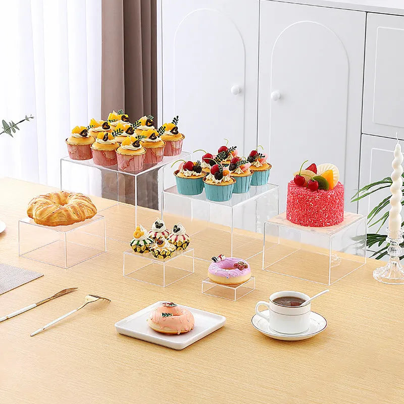 White plastic stacking cube dessert display stand set arranged in a pyramid for cakes and cupcakes.