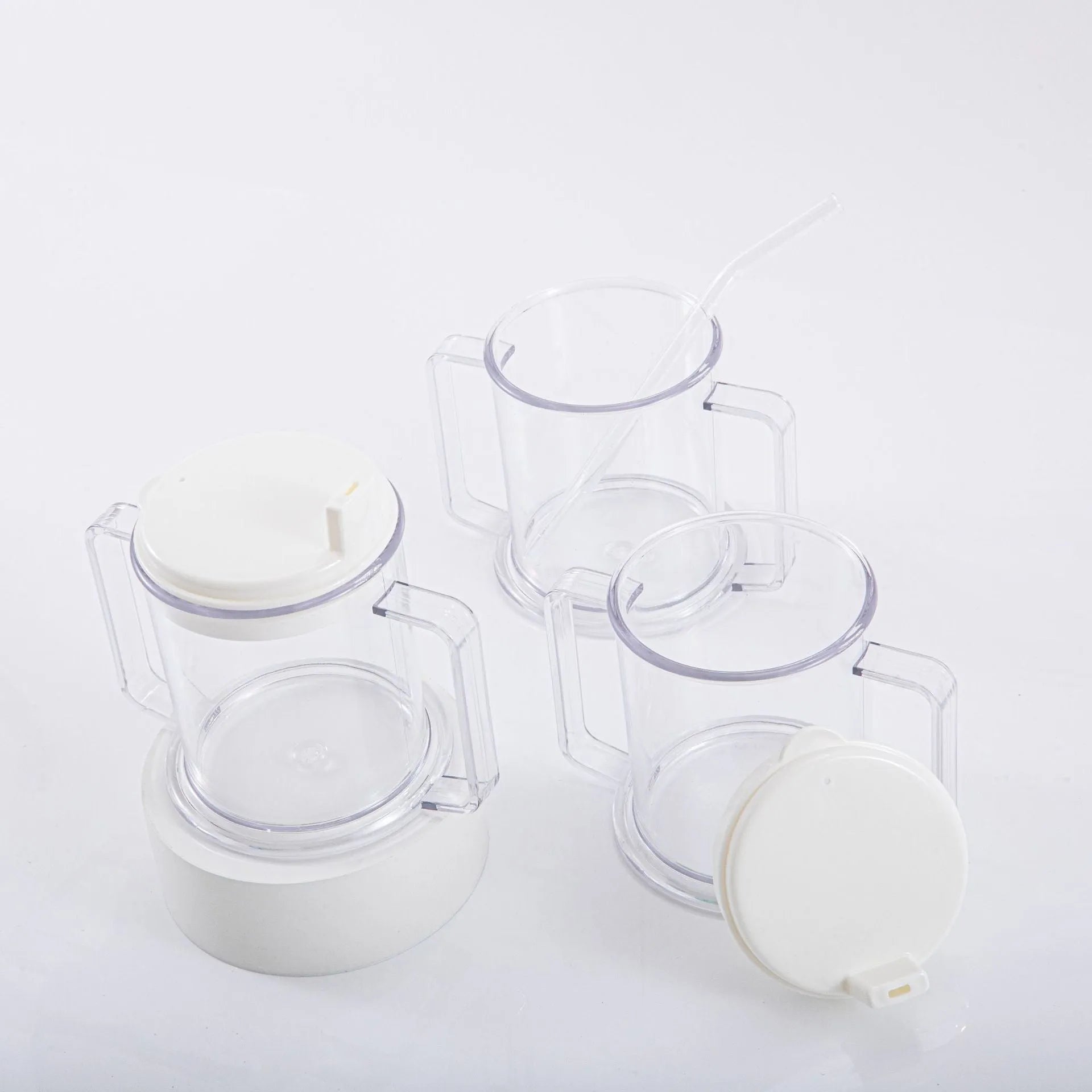 Transparent plastic drinking cup with spill-proof lid on a plain background.