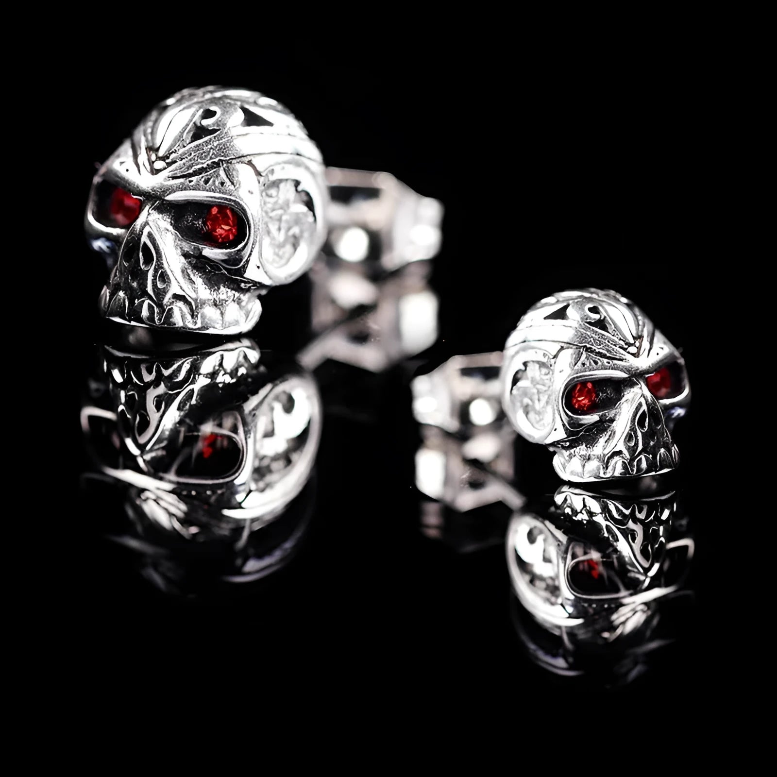 Skull stud earrings with red eye detailing on alloy base with gemstone inlay