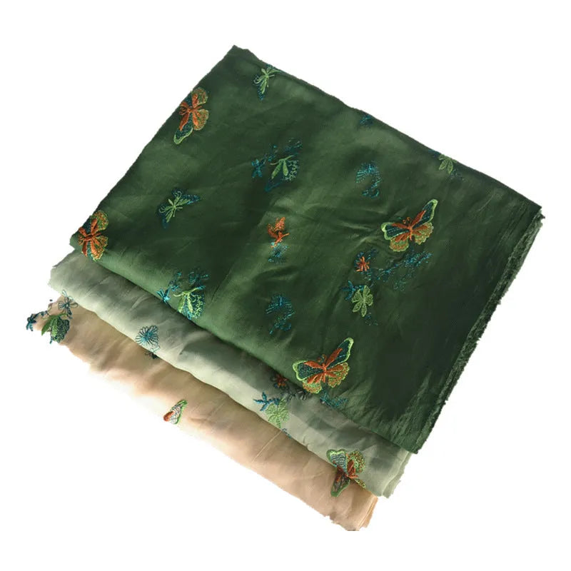 Close-up of pure ramie embroidery cloth in beige, dark green, and grass green colours, showing texture.