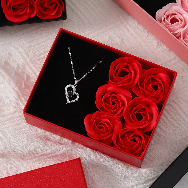 Red Korean-style gift box open to show six pink soap flowers, with a matching red handbag beside it.