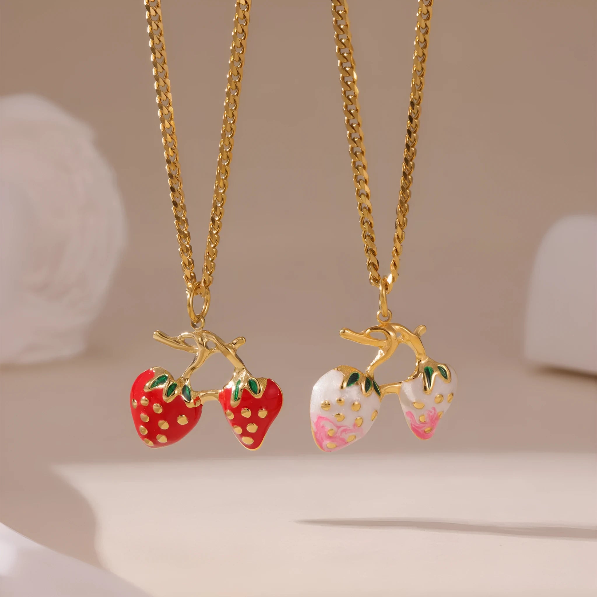 A stainless steel necklace with a strawberry fruit pendant in either red or white gradient colour.