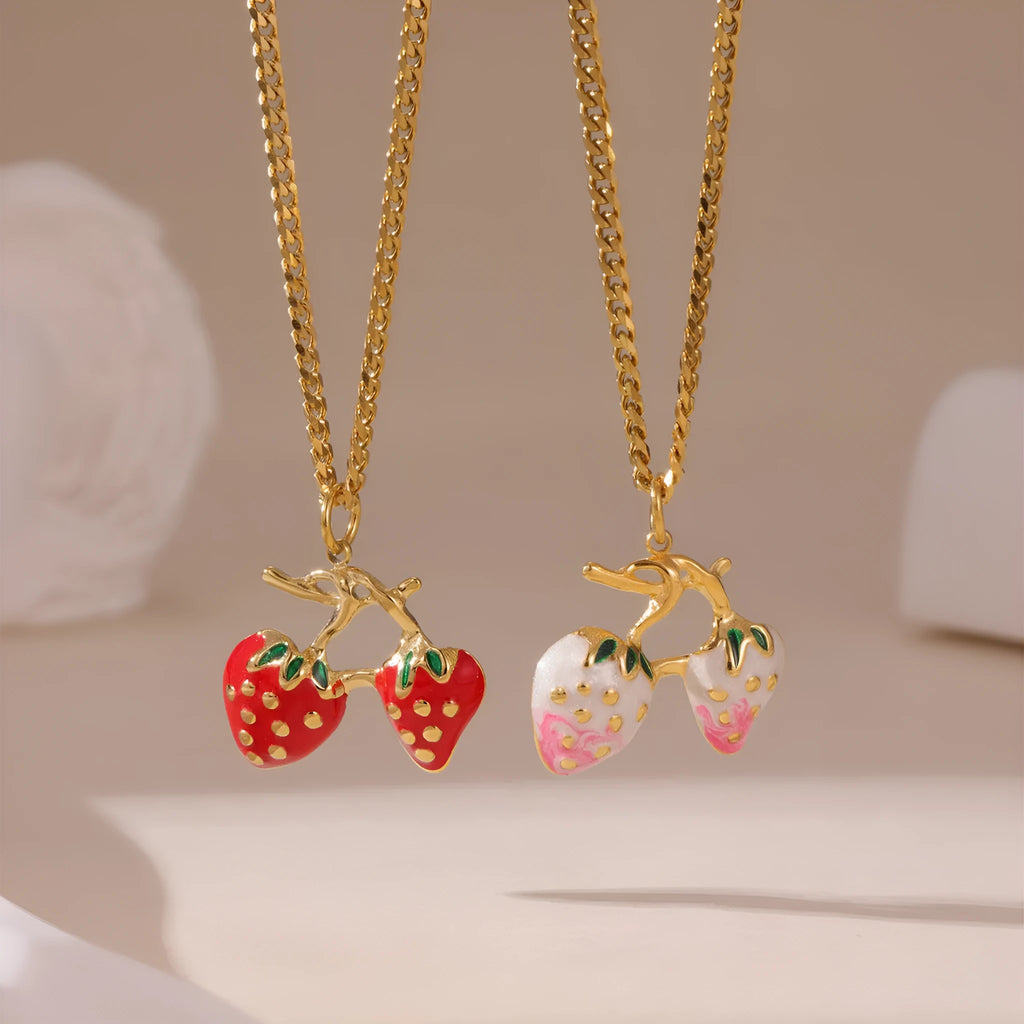 Close-up of a strawberry fruit charm necklace in red and white gradient on a stainless steel chain.