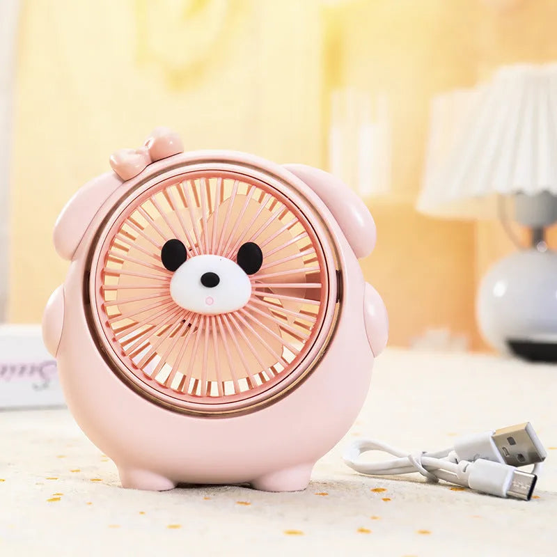 Cute dog-themed USB desktop electric fan in apricot puppy colour on a wooden desk.