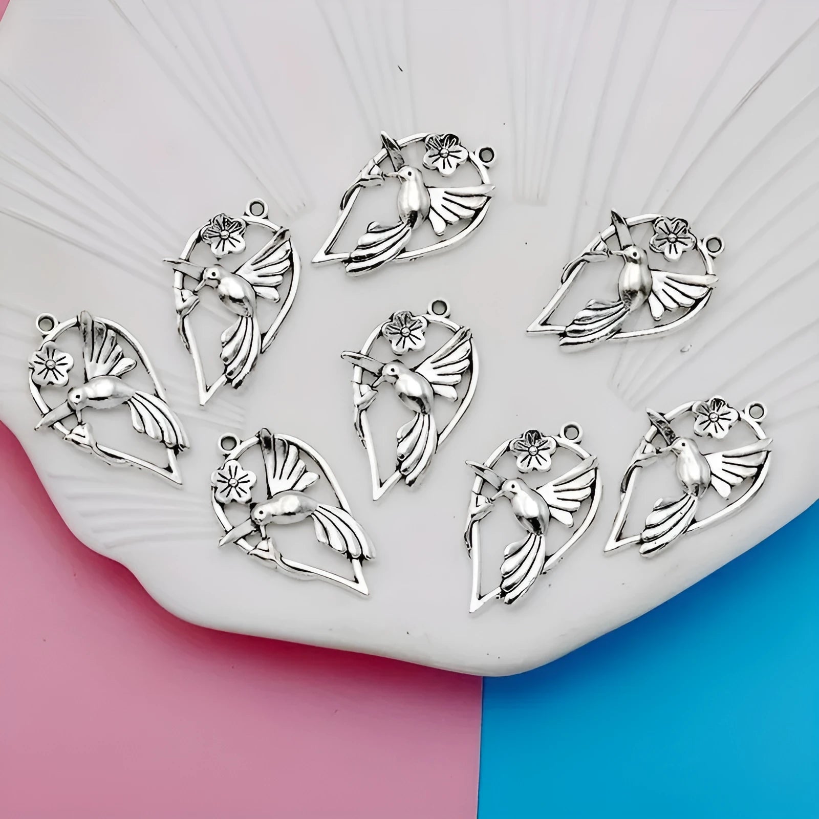 Close-up of a silver-grey alloy magpie pendant charm for DIY jewellery making on a white background.