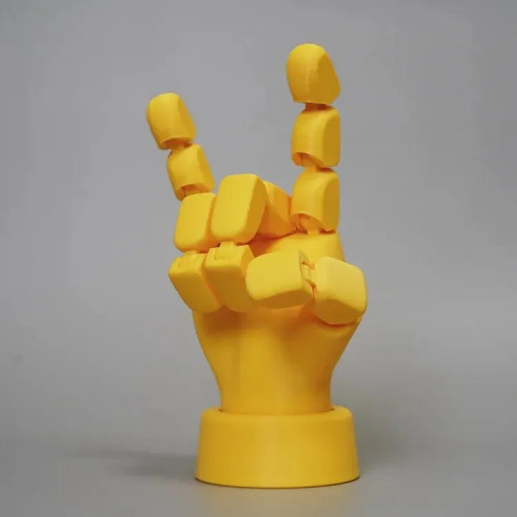 Yellow movable joint hand prop ornament with articulated fingers on a neutral background.