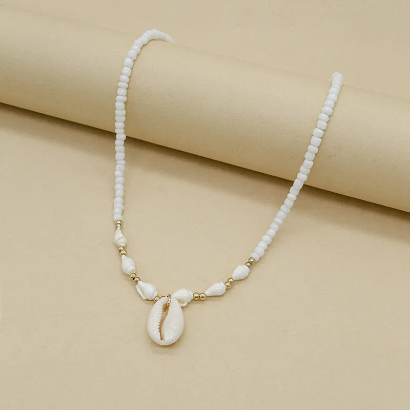 White conch-shaped mother pearl shell pendant necklace on a regular chain for women.