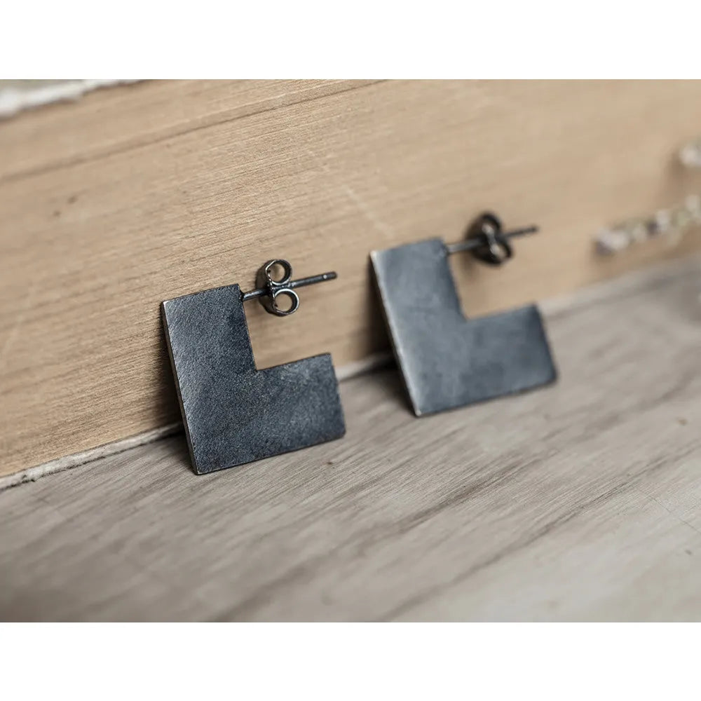 Oxidised black sterling silver square geometric earrings on a white background.