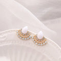 A pair of silver retro fan-shaped stud earrings with rhinestone details on a geometric design.