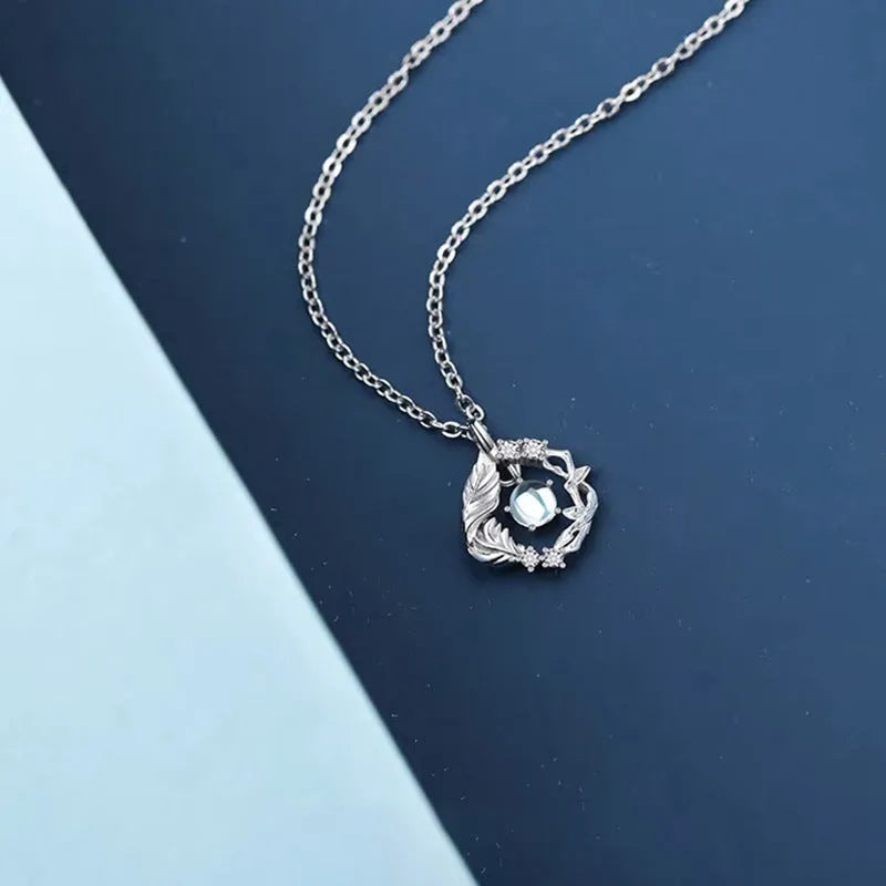 Geometric tree and bird pendant necklace with adjustable chain on display