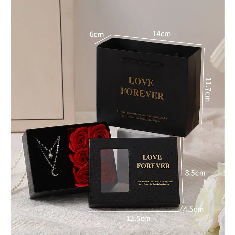 Red Korean-style gift box open to show six pink soap flowers, with a matching red handbag beside it.