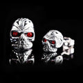 Skull stud earrings with red eye detailing on alloy base with gemstone inlay