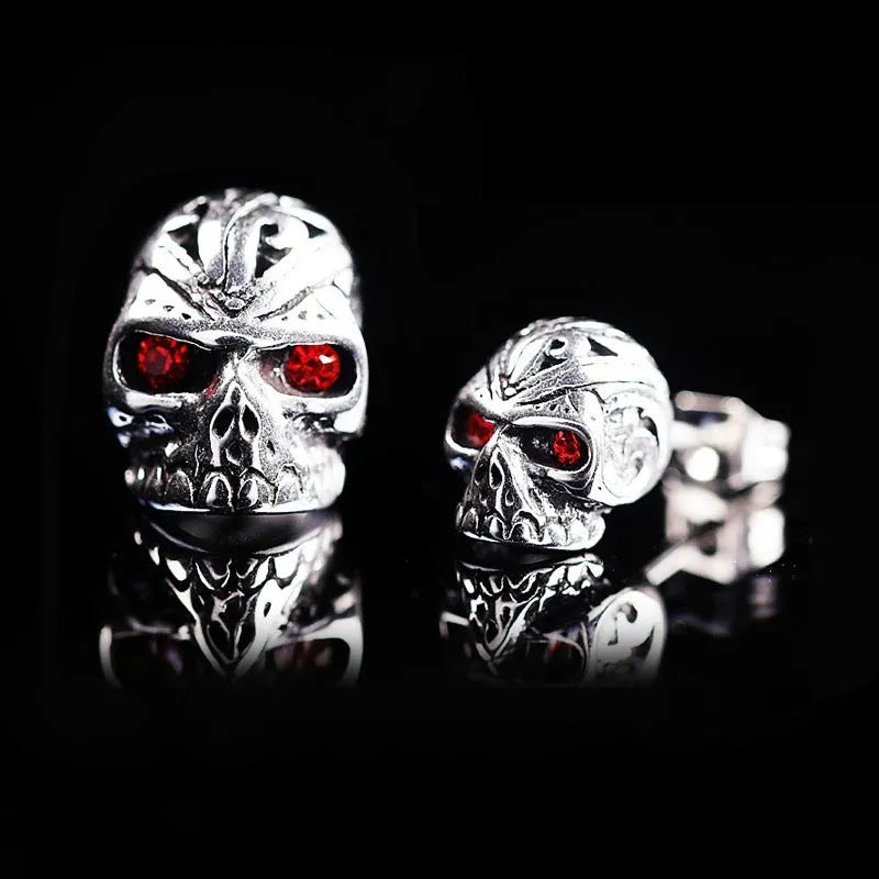 Skull stud earrings with red eye detailing on alloy base with gemstone inlay