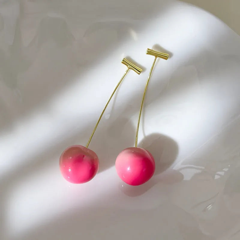 A pair of women's acrylic earrings shaped like juicy peaches, shown in small and large size options.