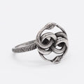 Close-up of a retro-style titanium steel double snake ring in a steel colour on a hand.