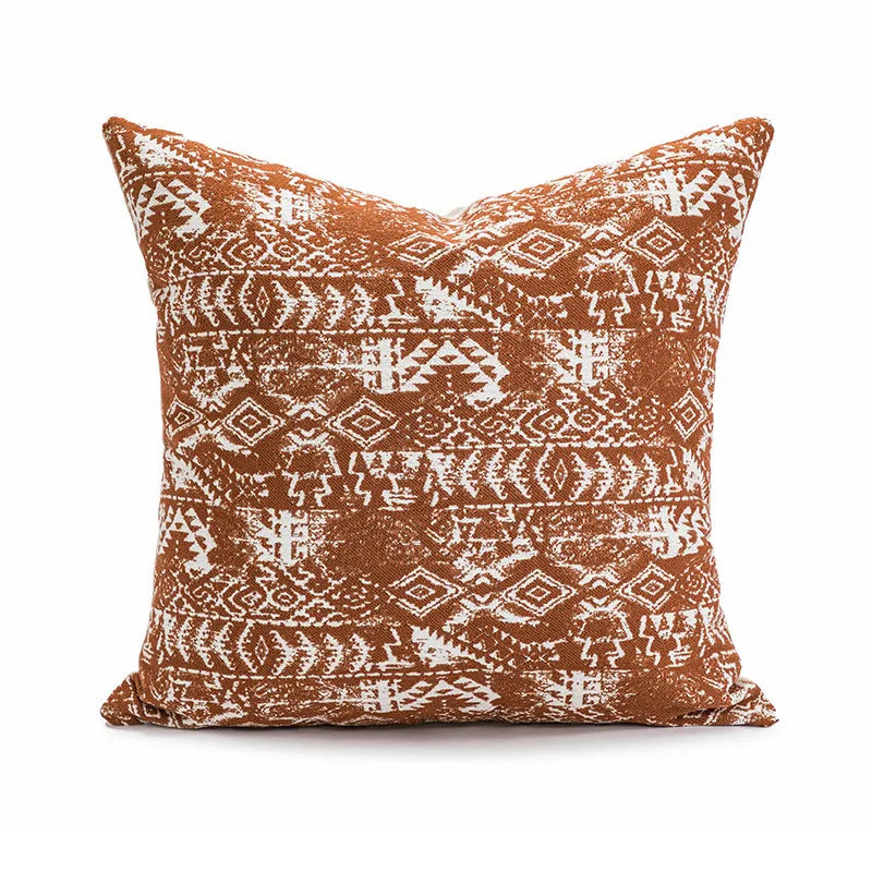 A square pp cotton pillow cushion with a solid red-brown abstract print cover on a sofa.