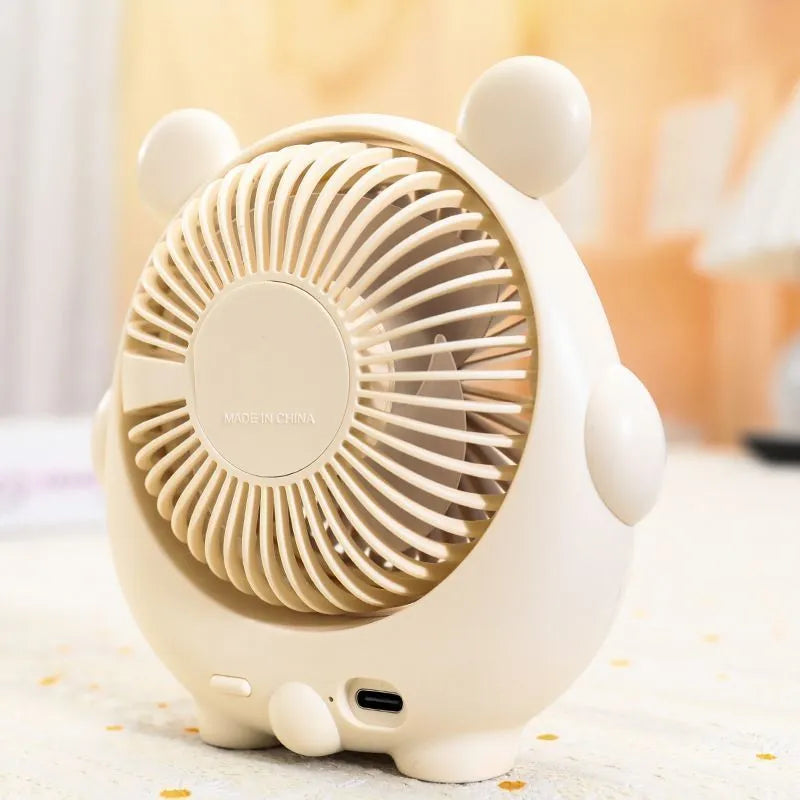 Cute dog-themed USB desktop electric fan in apricot puppy colour on a wooden desk.