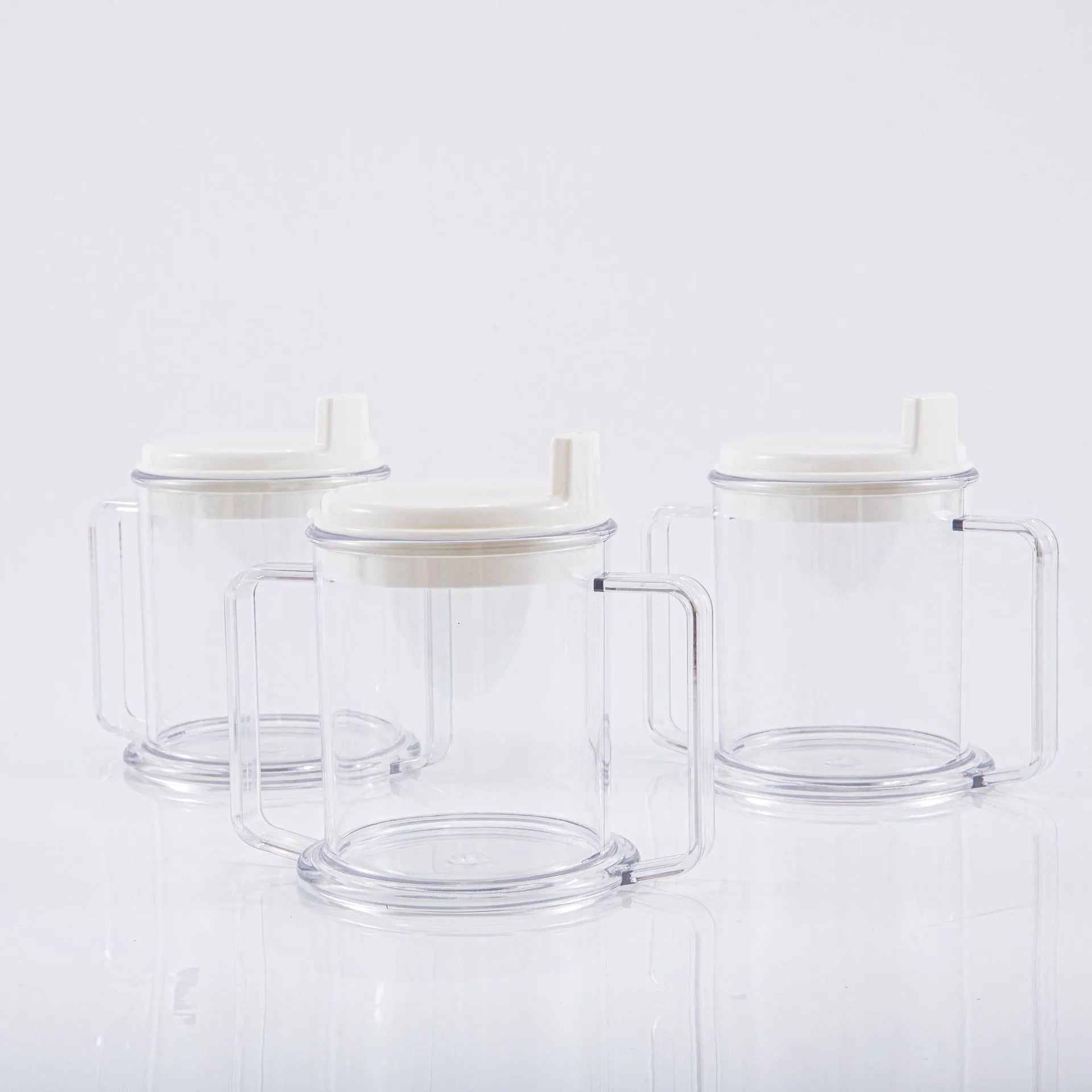 Transparent plastic drinking cup with spill-proof lid on a plain background.