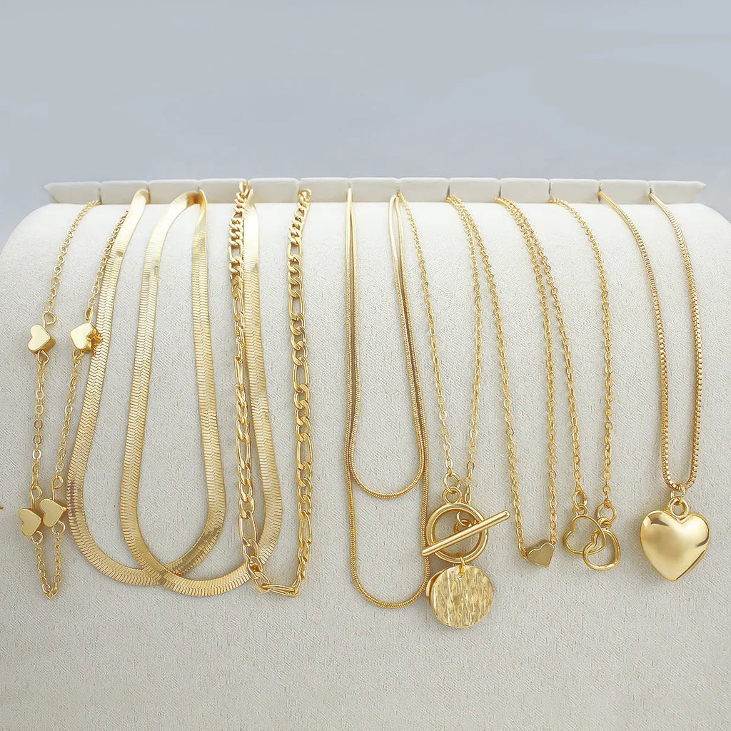 Set of ten simple gold women's necklaces with alloy pendants on snake bone chains.