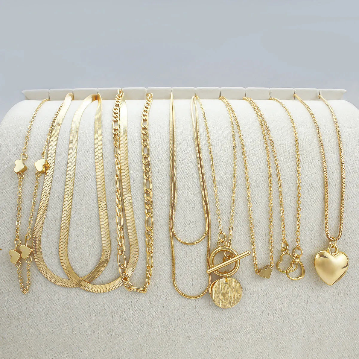 Set of ten simple gold women's necklaces with alloy pendants on snake bone chains.