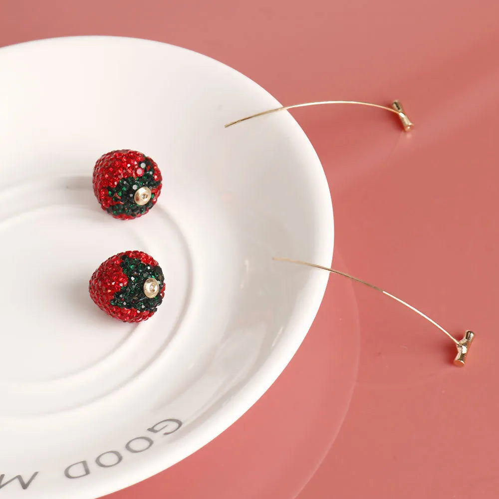 Pair of geometric strawberry stud earrings with spot drill texture in red zinc alloy, shown from front.