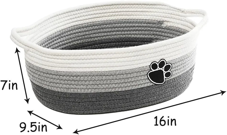 Light beige handmade woven cotton rope storage basket with a wooden handle on a wooden floor.