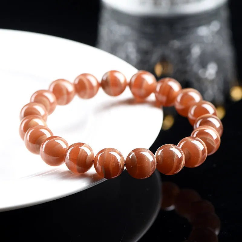 Natural Old Mine Rhodochrosite round bead bracelet with Ruyi charm, shown in 6mm and 8mm size options.