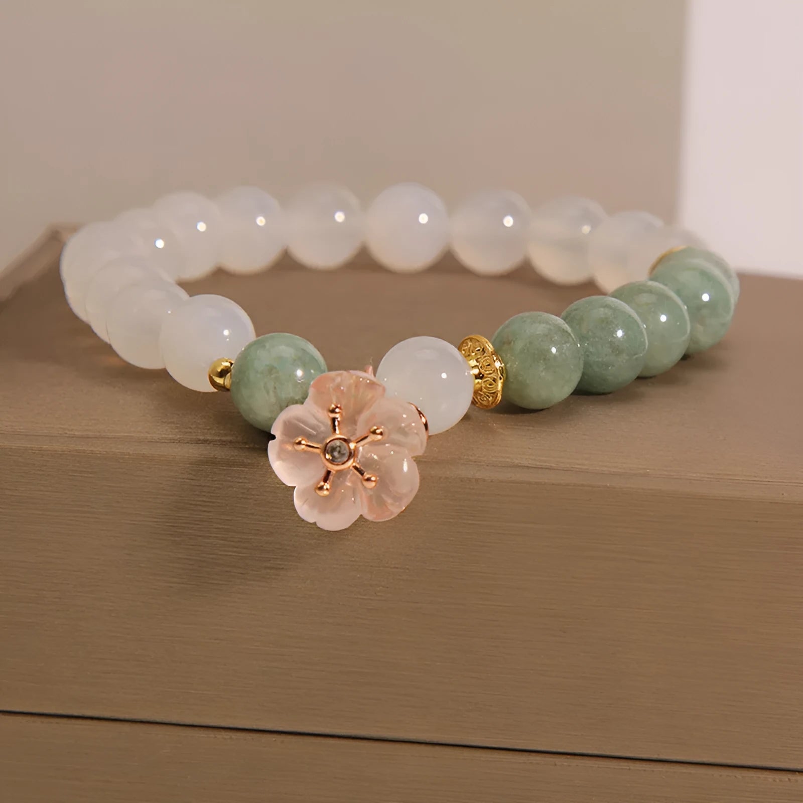 White agate floral bracelet with jade details and adjustable clasp on woman's wrist