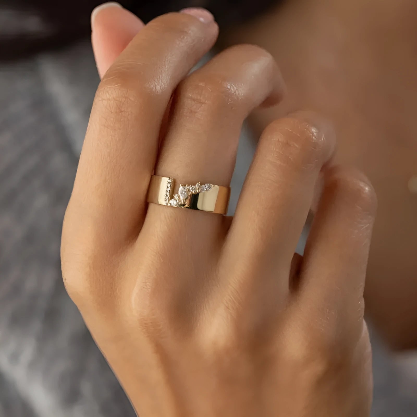 Gold plated women's ring with a shining zircon stone on a model's hand.