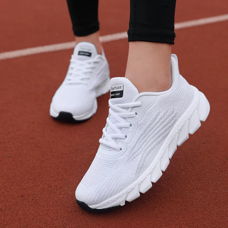 Low-top black and white running sneaker with cross strap and round toe on MD sole.