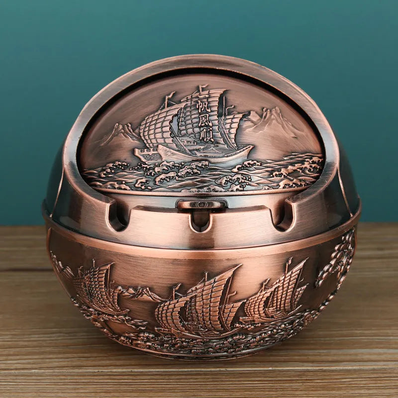 Alloy decorative ashtray in bronze with ornate peacock motif and cigarette extinguishing slot.