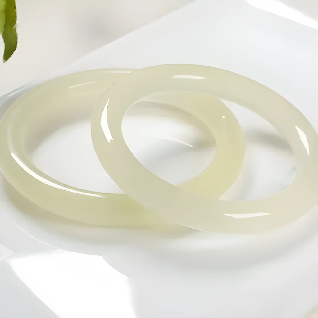 Ice silk jade round bar bracelet on a wrist, showing its smooth, continuous loop and polished stone finish.