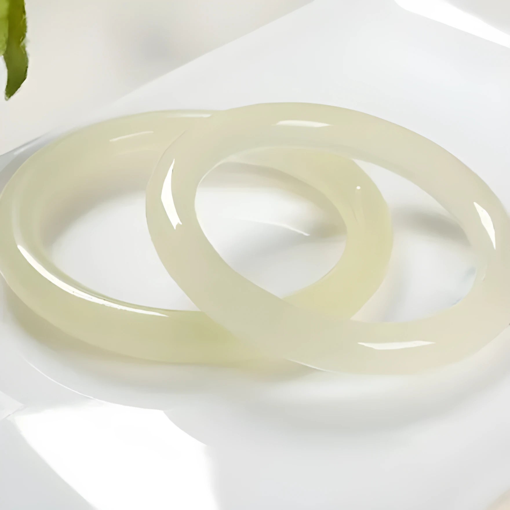 Ice silk jade round bar bracelet on a wrist, showing its smooth, continuous loop and polished stone finish.