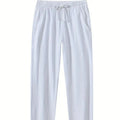 Men's loose-fitting cotton beach trousers in a solid colour, shown in a casual setting.