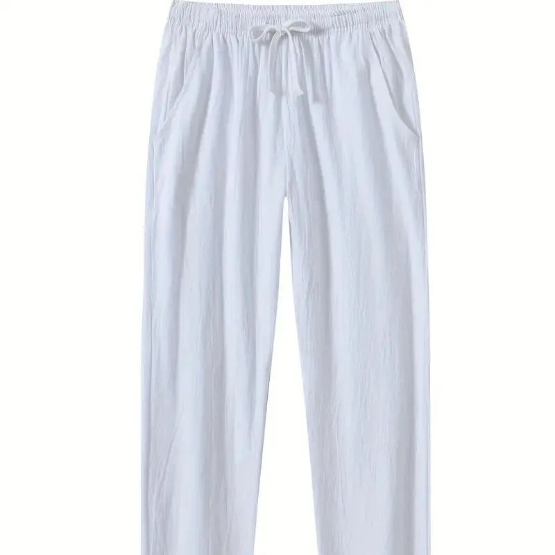 Men's loose-fitting cotton beach trousers in a solid colour, shown in a casual setting.